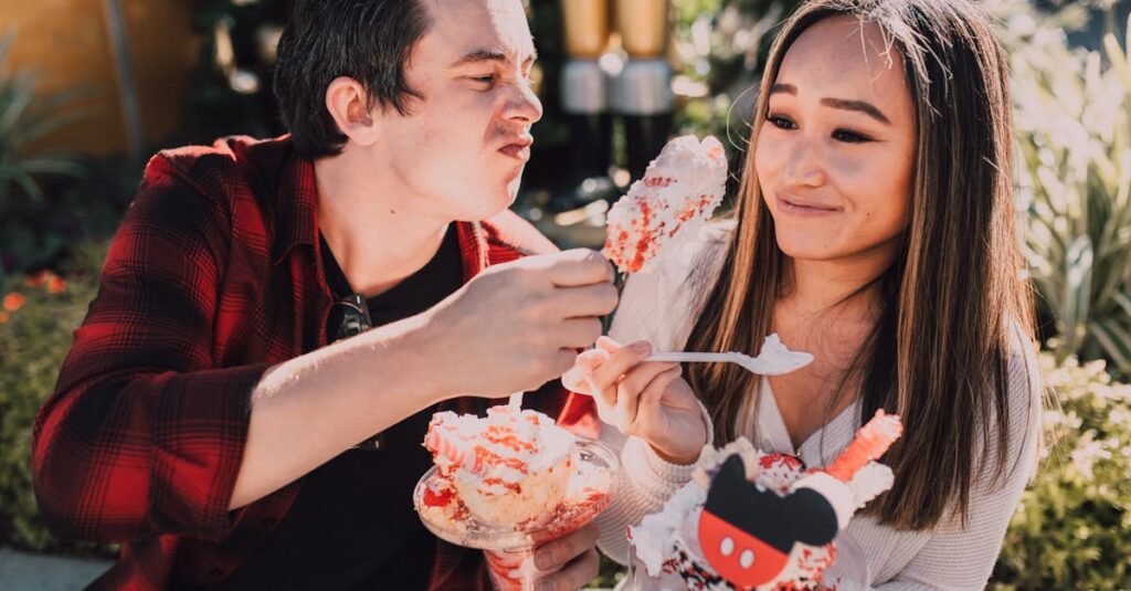 A young couple enjoying colorful desserts on a sunny day outdoors, sharing laughter.